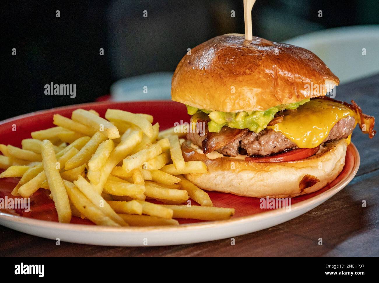 a close up image of a Guacamole and bacon filled beef burger served ...