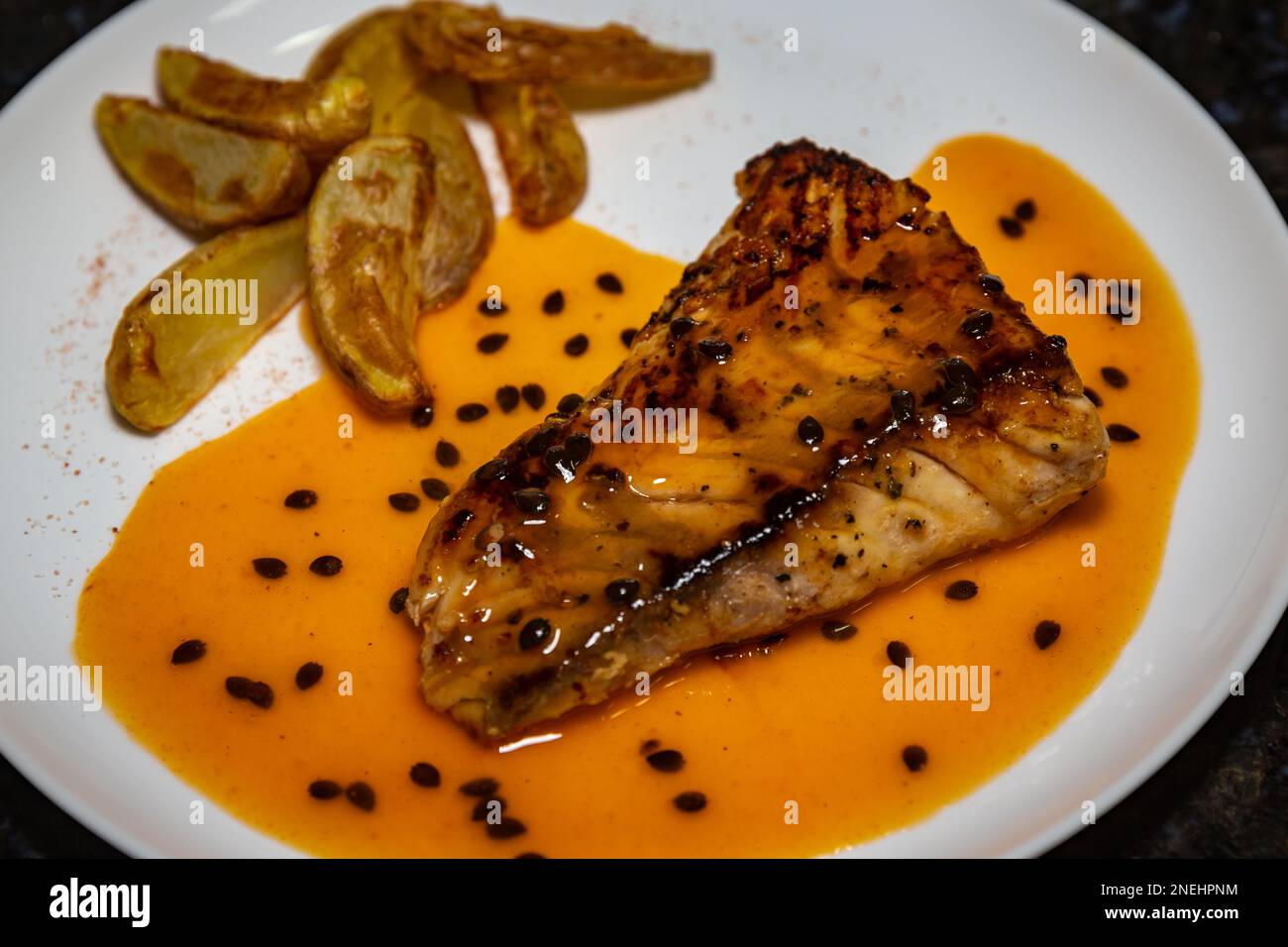 Traditional grilled fish (sea bass) with passion fruit sauce. Closeup