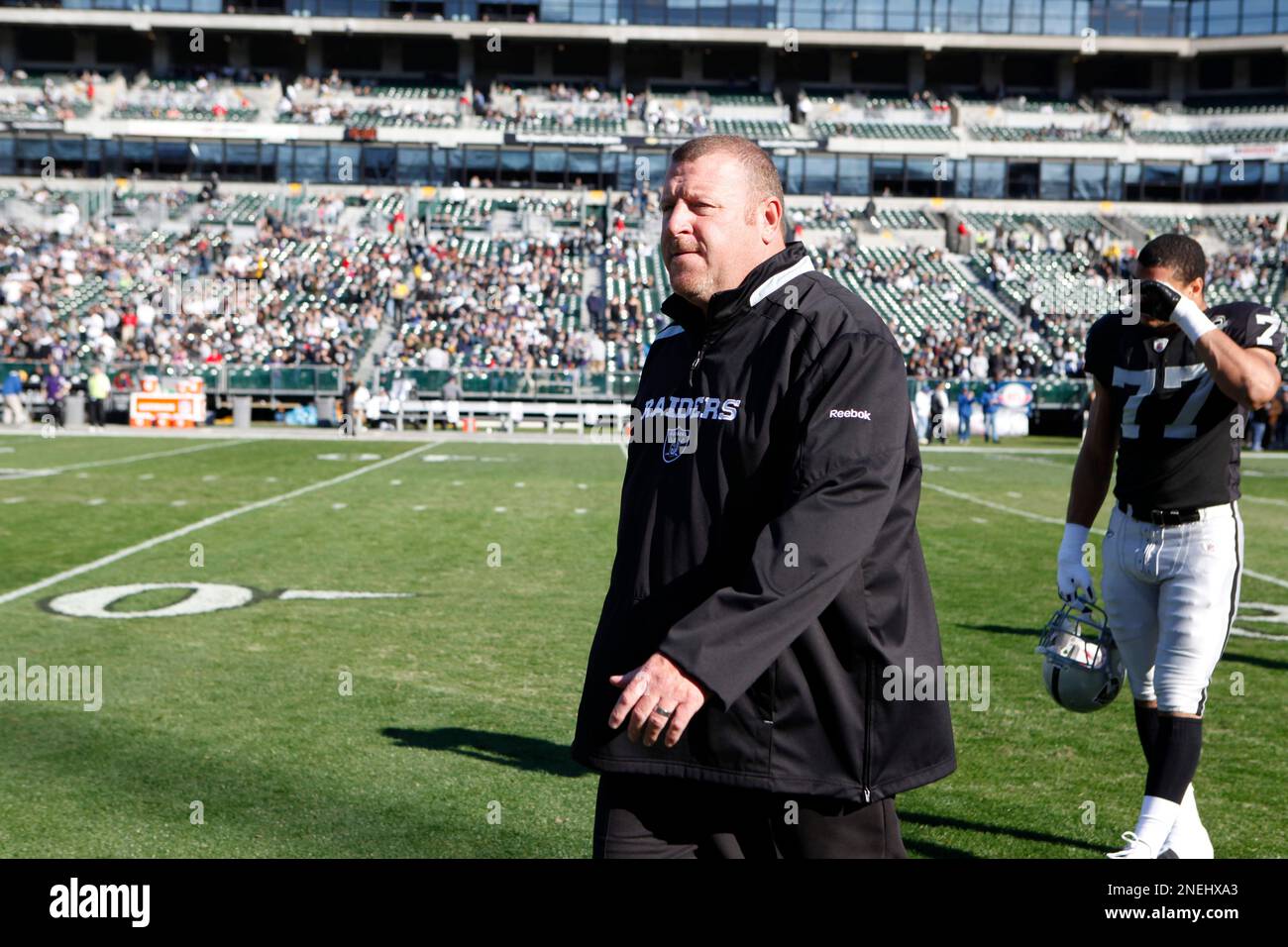 Oakland Raiders' head coach Tom Cable and Matt Shaughnessy (77) walk on