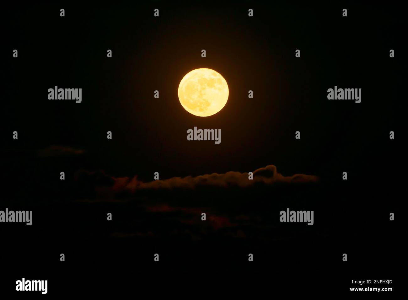 Rise of the orange moon, also known as the harvest moon or the hunter's moon, over the night sky at Sikkim, India. Moon orange due to atmosphere. Stock Photo