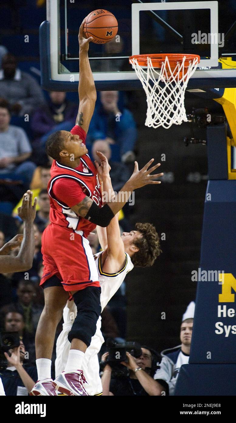 Detroit center Eli Holman, left, dunks on Michigan guard Zack Novak