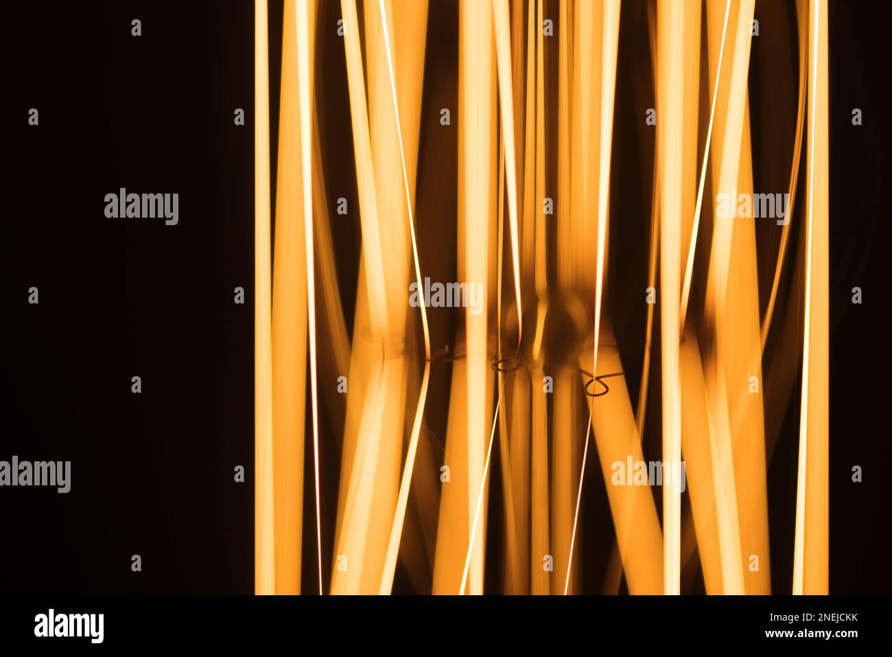 Tungsten filament of a lamp glowing in dark, macro photo background