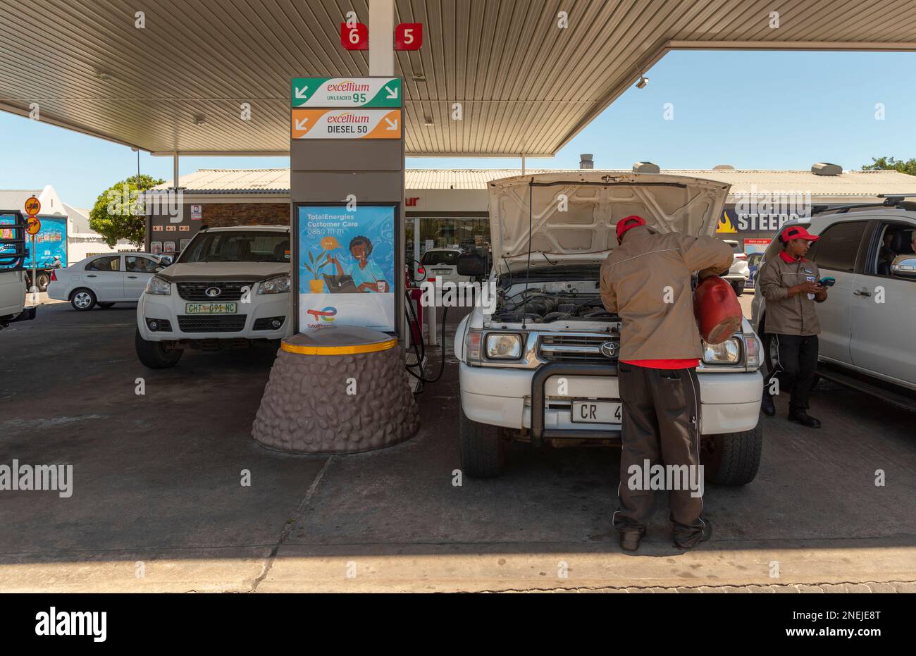 Langebaan, Western Cape, South Africa. 2023. Service station attendant checking water levels on a vehicle during a fuel stop. Stock Photo