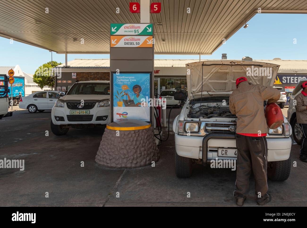 Langebaan, Western Cape, South Africa. 2023. Service station attendant checking water levels on a vehicle during a fuel stop. Stock Photo