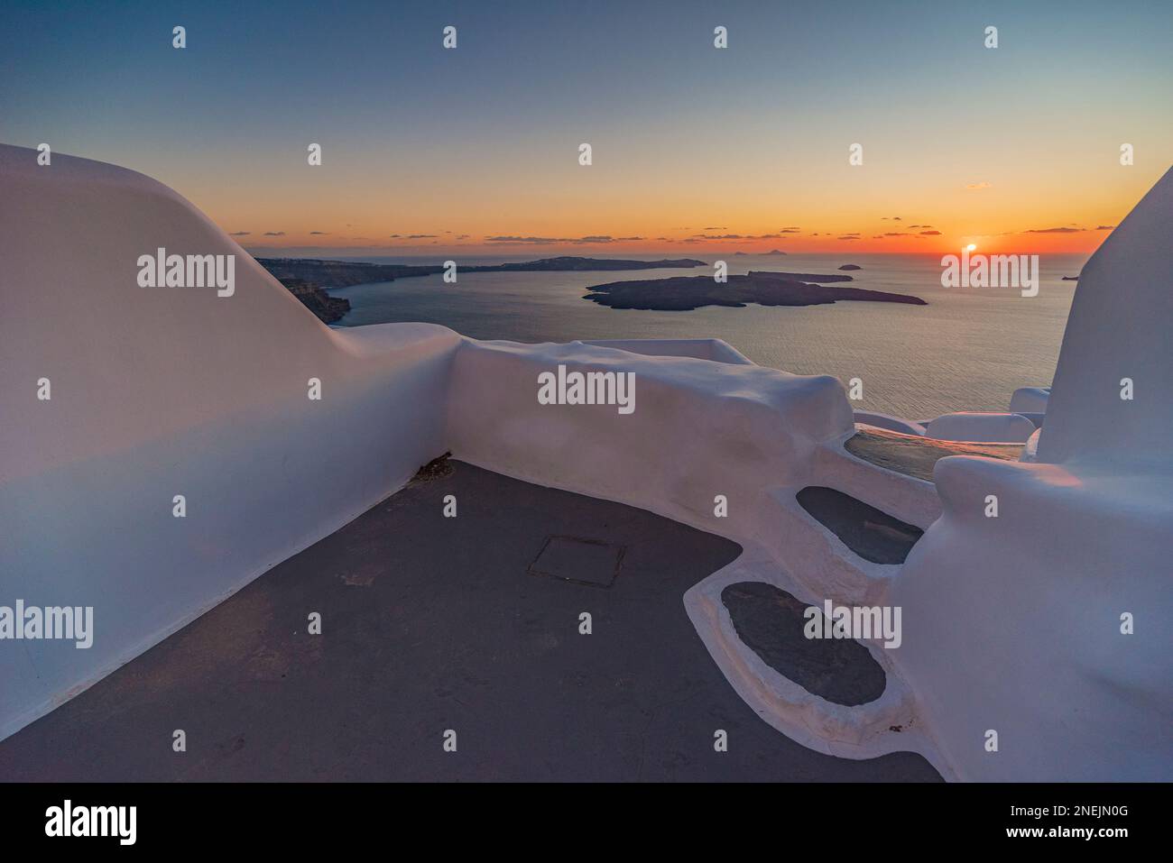 Sun setting over the caldera seen from a terrace overlooking the sea, Santorini Stock Photo