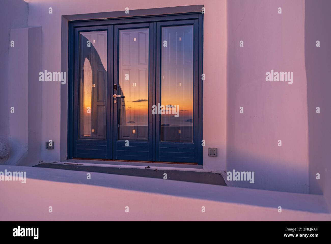 Sunset reflected on the glass window, Santorini Stock Photo