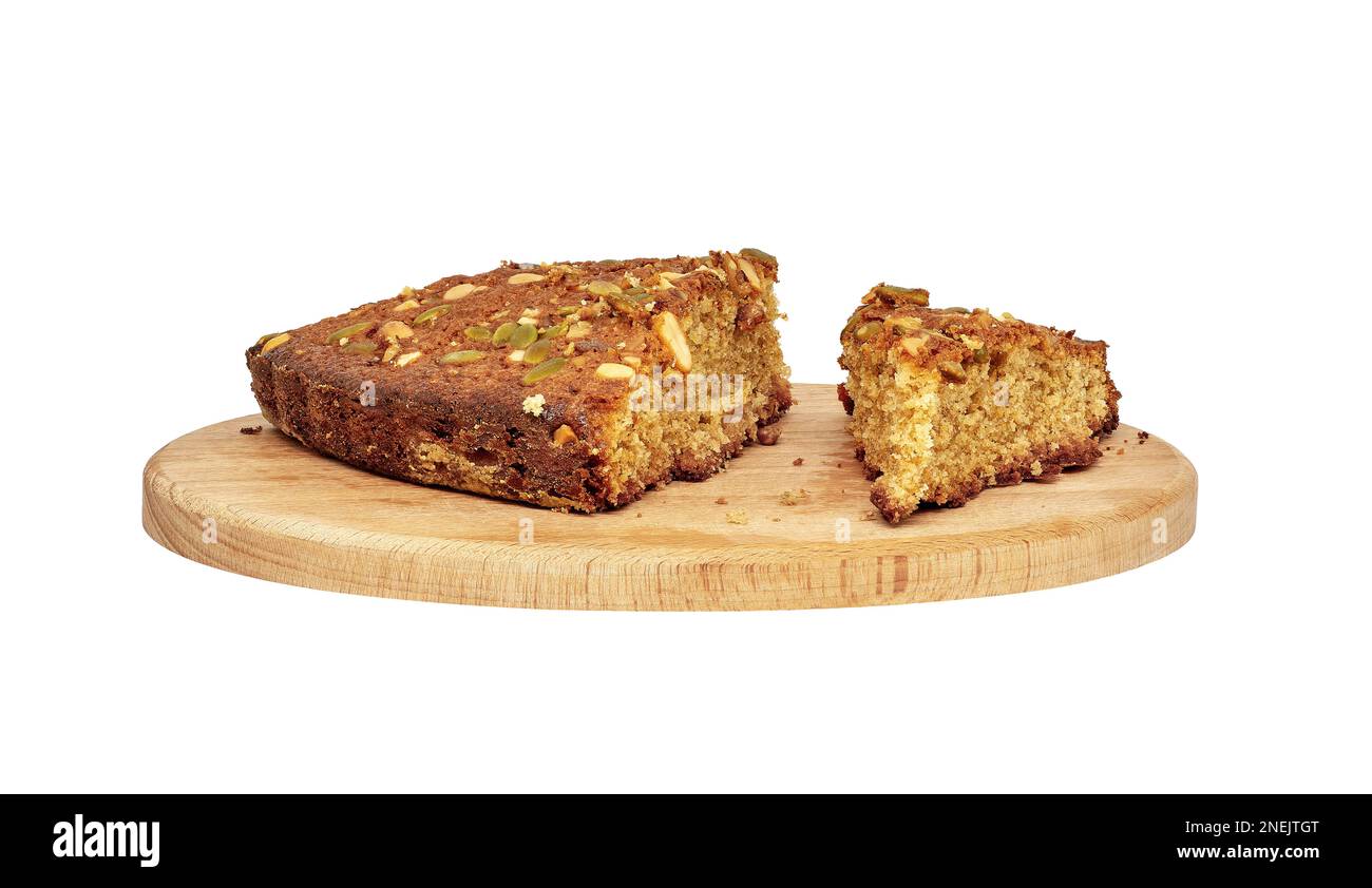 Image of several pieces of homemade sponge cake with nuts on a wooden cutting board Stock Photo