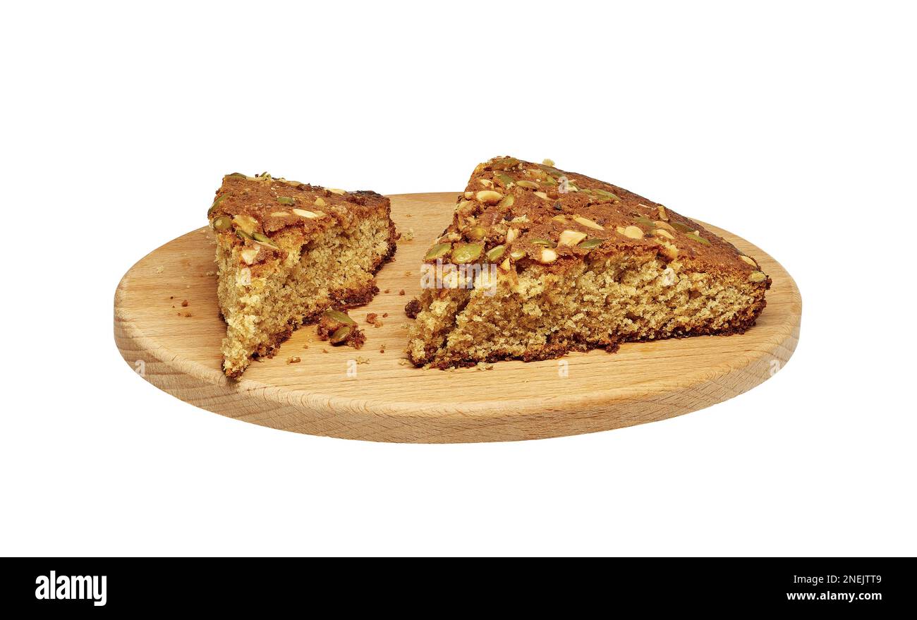 Image of several pieces of homemade sponge cake with nuts on a wooden cutting board Stock Photo