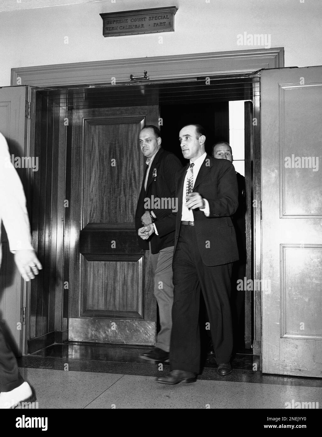 Shackled to a guard, Raymond M. Fernandez, right, convicted "Lonely Hearts"  slayer, leaves a court room in Bronx County Courthouse, New York, en route  to the death house at Sing Sing Prison,