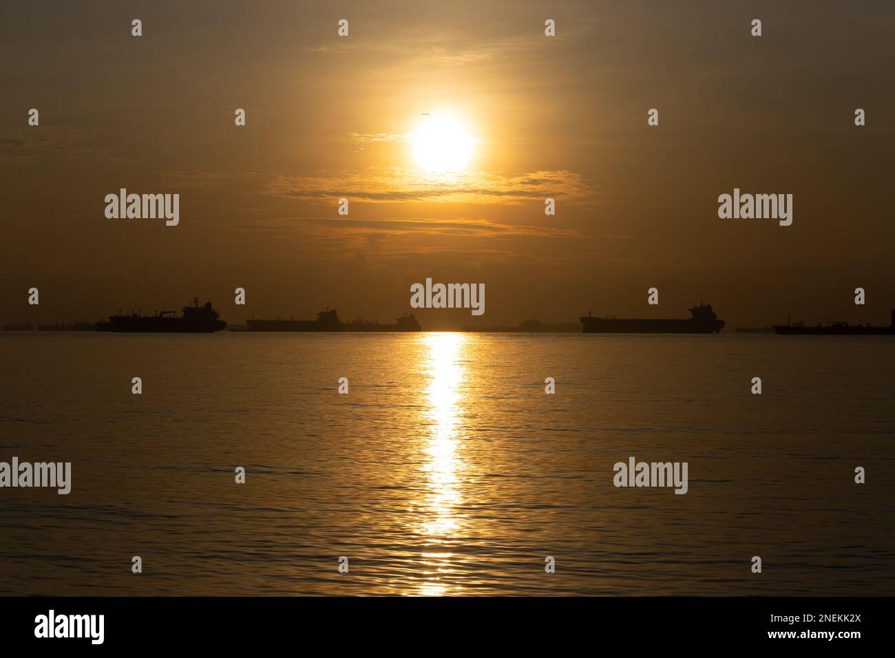 Container Ships off the Shore of Singapore, in the Singapore Strait, During Sunrise - Singapore Stock Photo