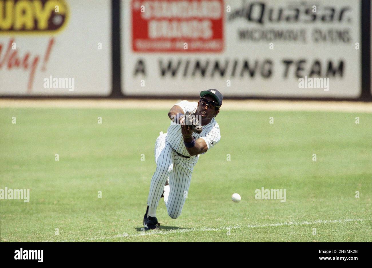 New York Yankee right fielder Deion Sanders tries to make a diving