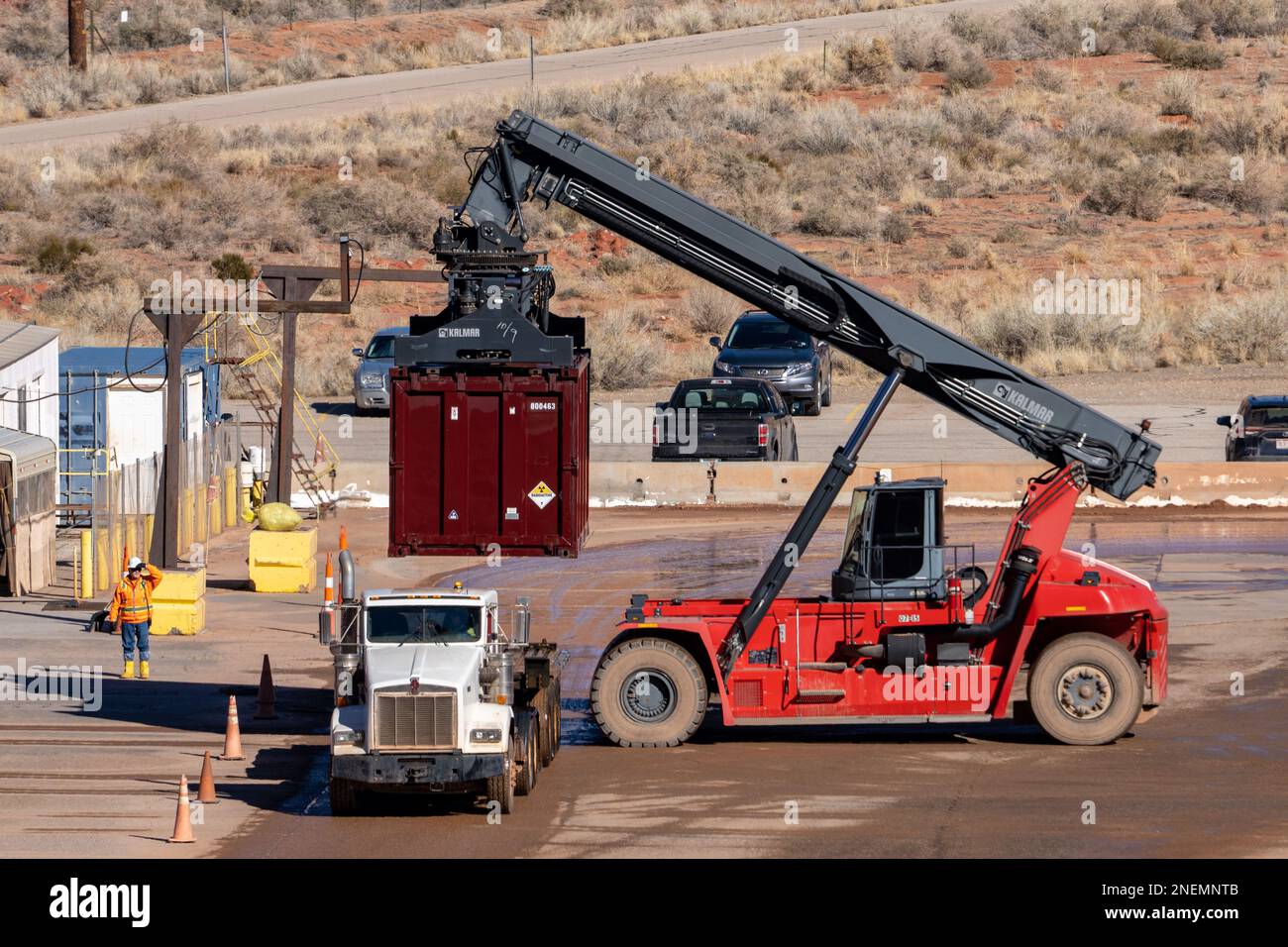 A reachstacker container handler removes a filled and washed container from a dirty truck at the