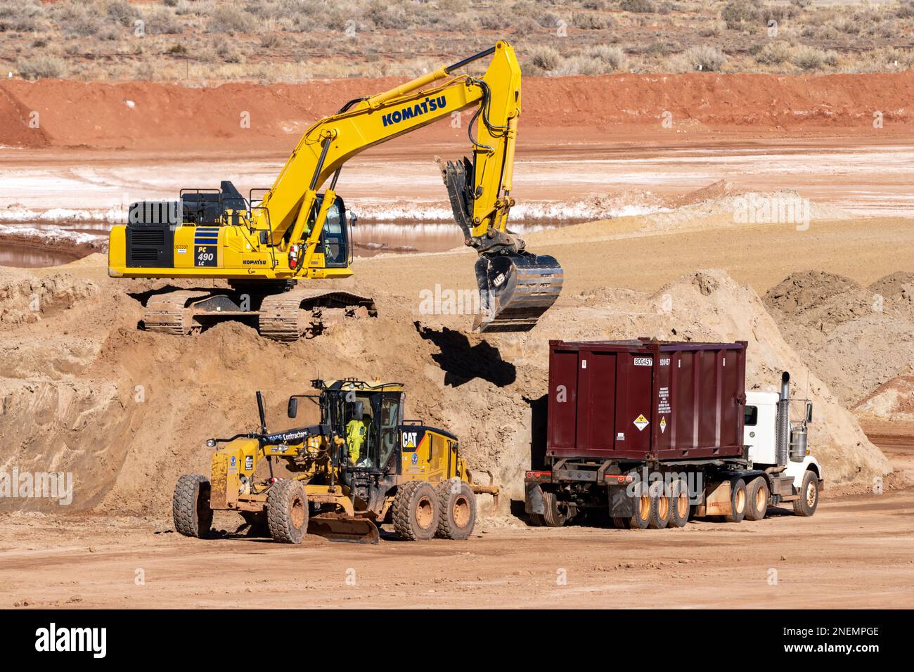 A heavy duty excavator loads a container truck with hazardous uranium tailings at the UMTRA remediation project, Moab, Utah. Stock Photo