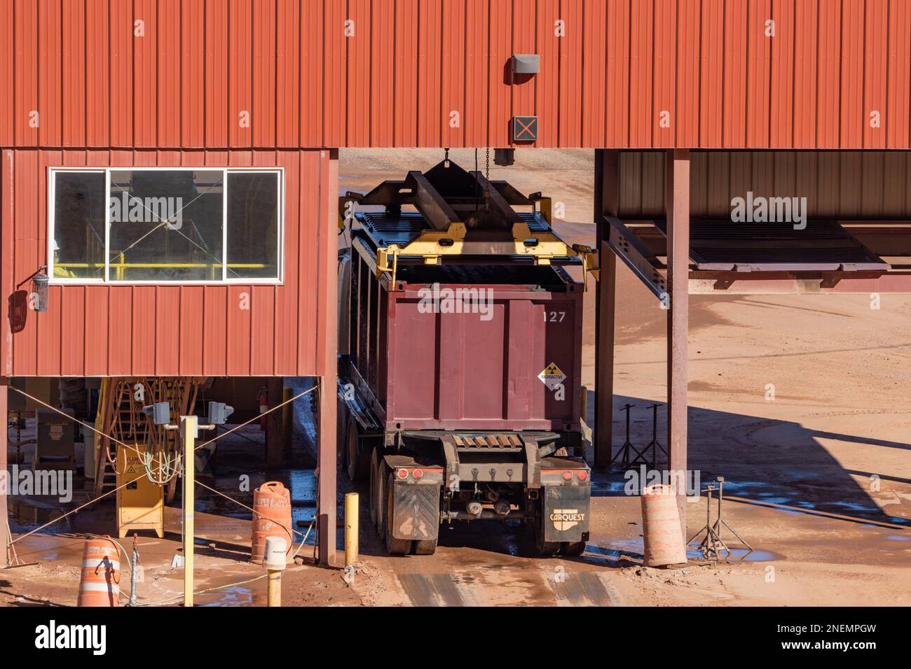 A filled container truck having its container capped at the UMTRA tailings project in Moab, Utah.  A sliding hoist is dropping the cap onto to the con Stock Photo