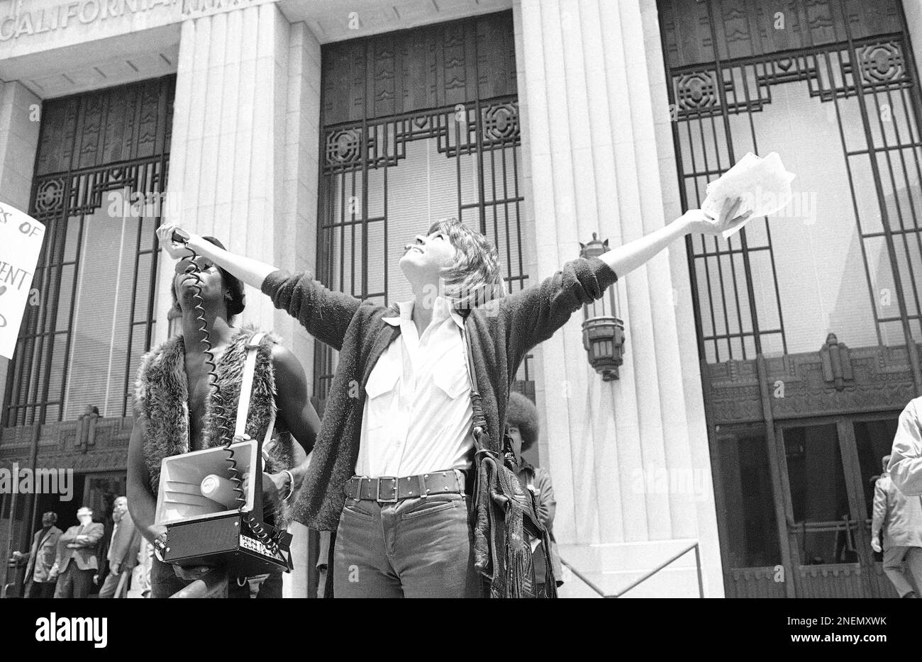 Actress Jane Fonda raises her arms in frustration over the noise of a