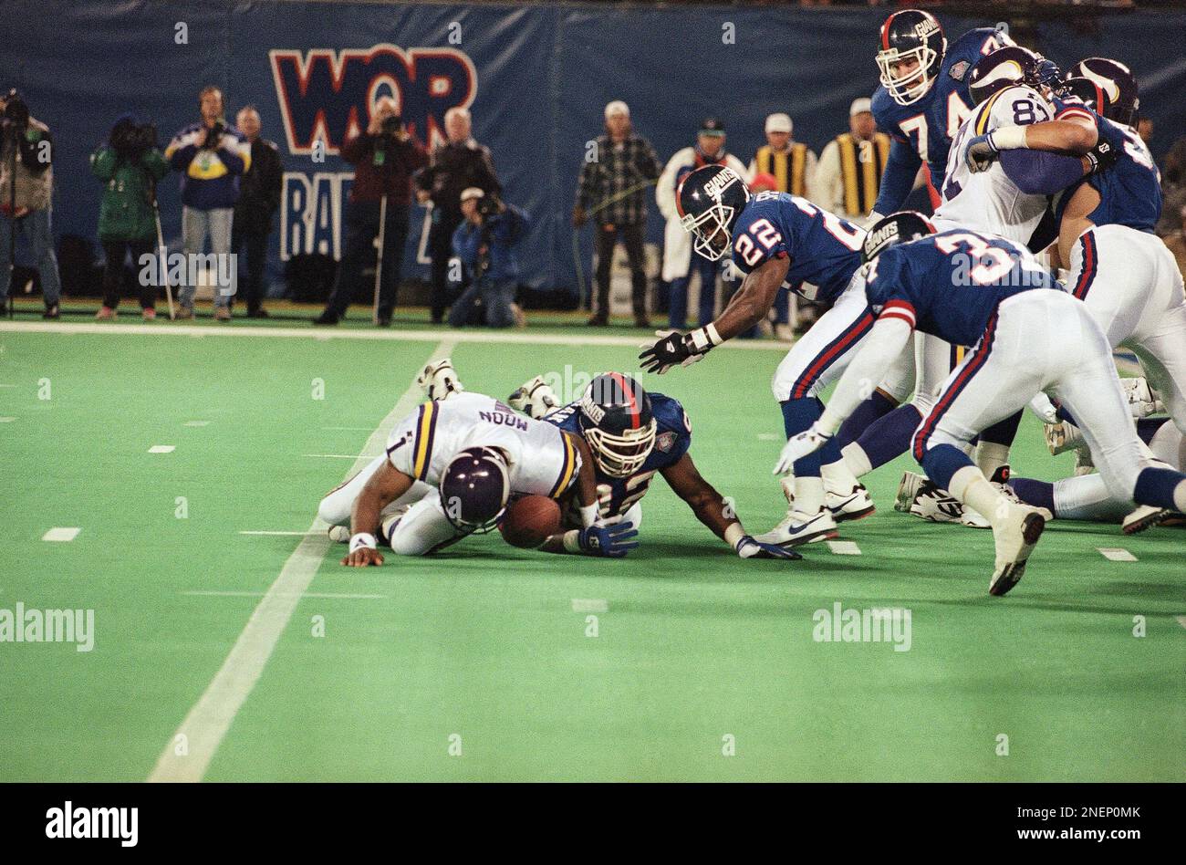 Minnesota Vikings quarterback Warren Moon, left, fights New York Giants