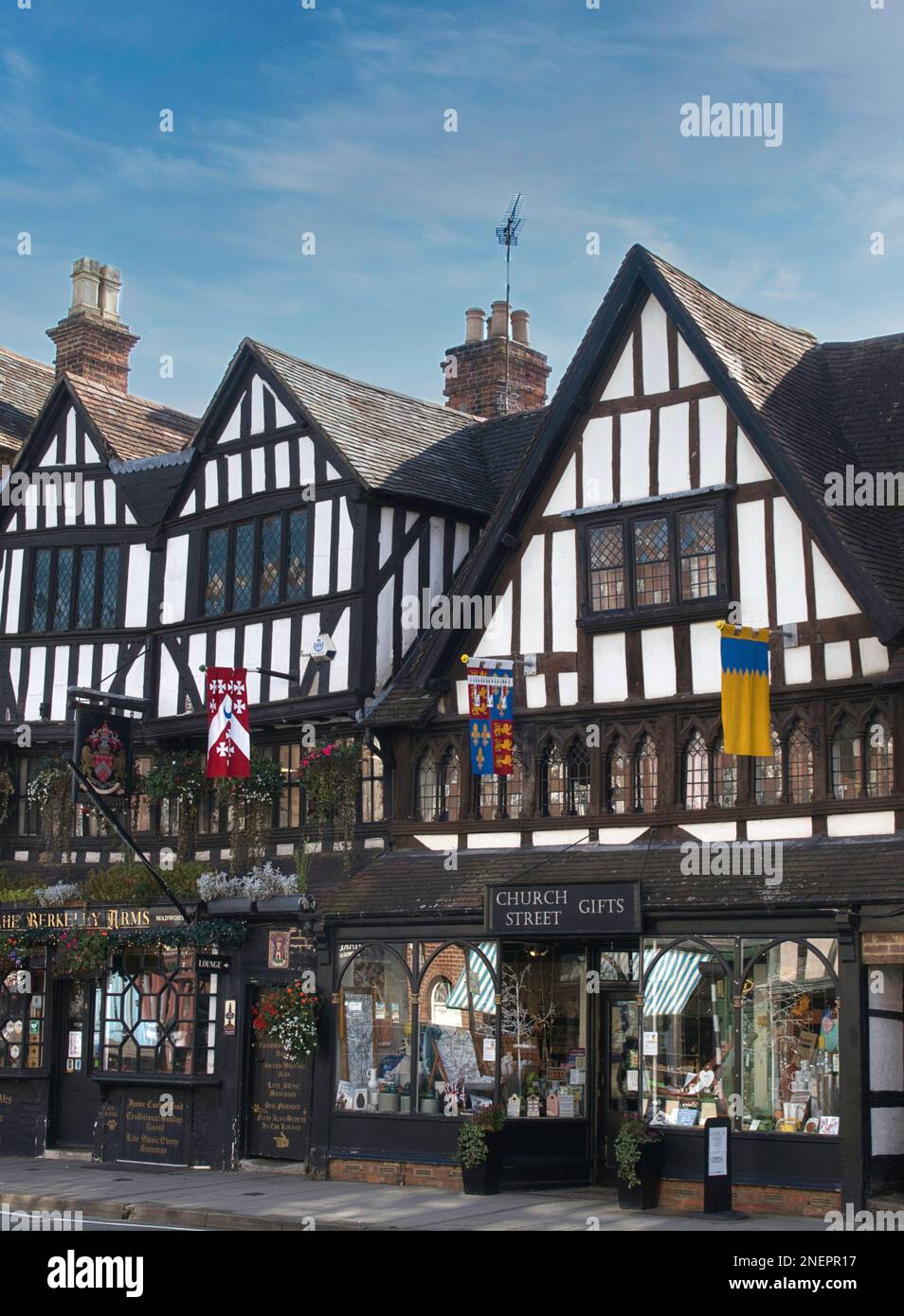 A pub and shop beneath half-timbered upper storey of tudor style building in Tewkesbury, Gloucestershire, England Stock Photo