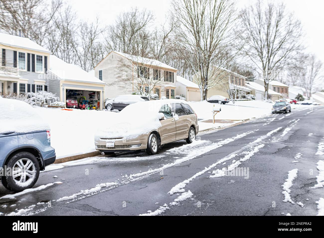 Community neighborhood single family houses with cars on street covered