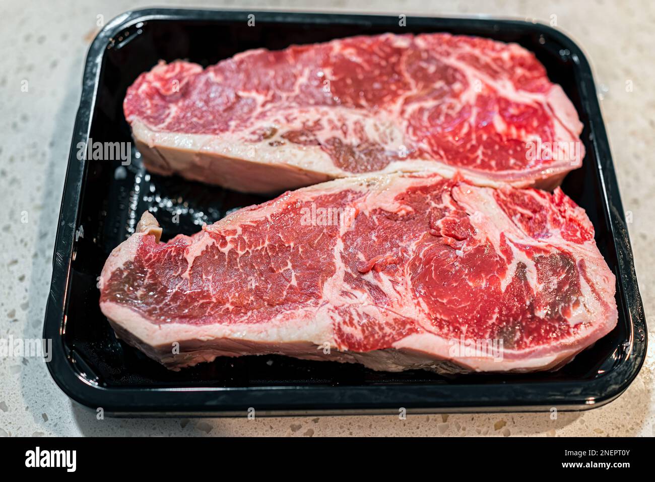 Two red raw strip steaks cuts of meat closeup macro of texture from