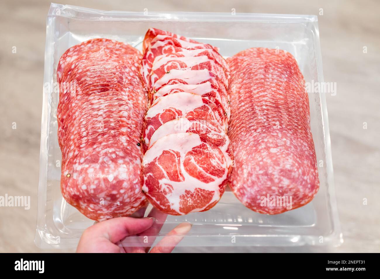 Salami slices with uncured sopressata, coppa and genoa salami with no nitrites on plastic tray with red meat pork Stock Photo