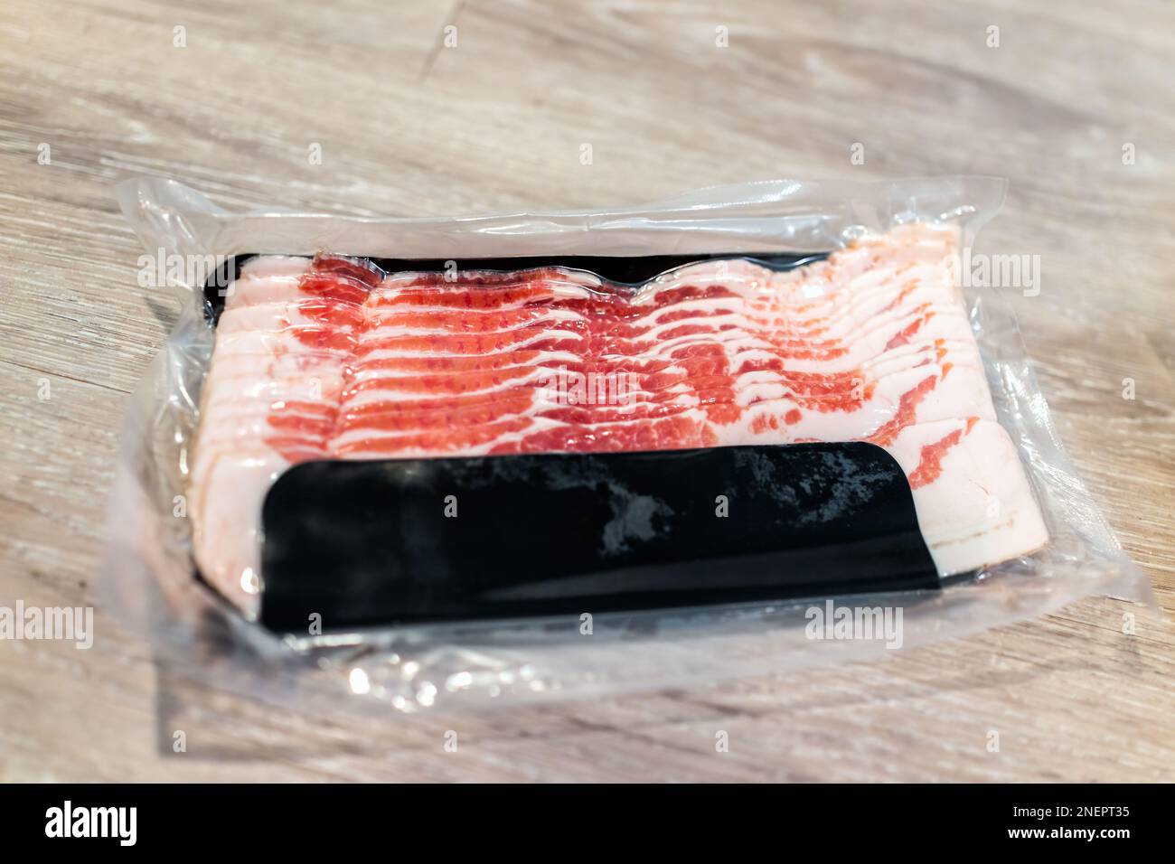 Smoked uncured bacon storebought in plastic vacuum sealed pack with red