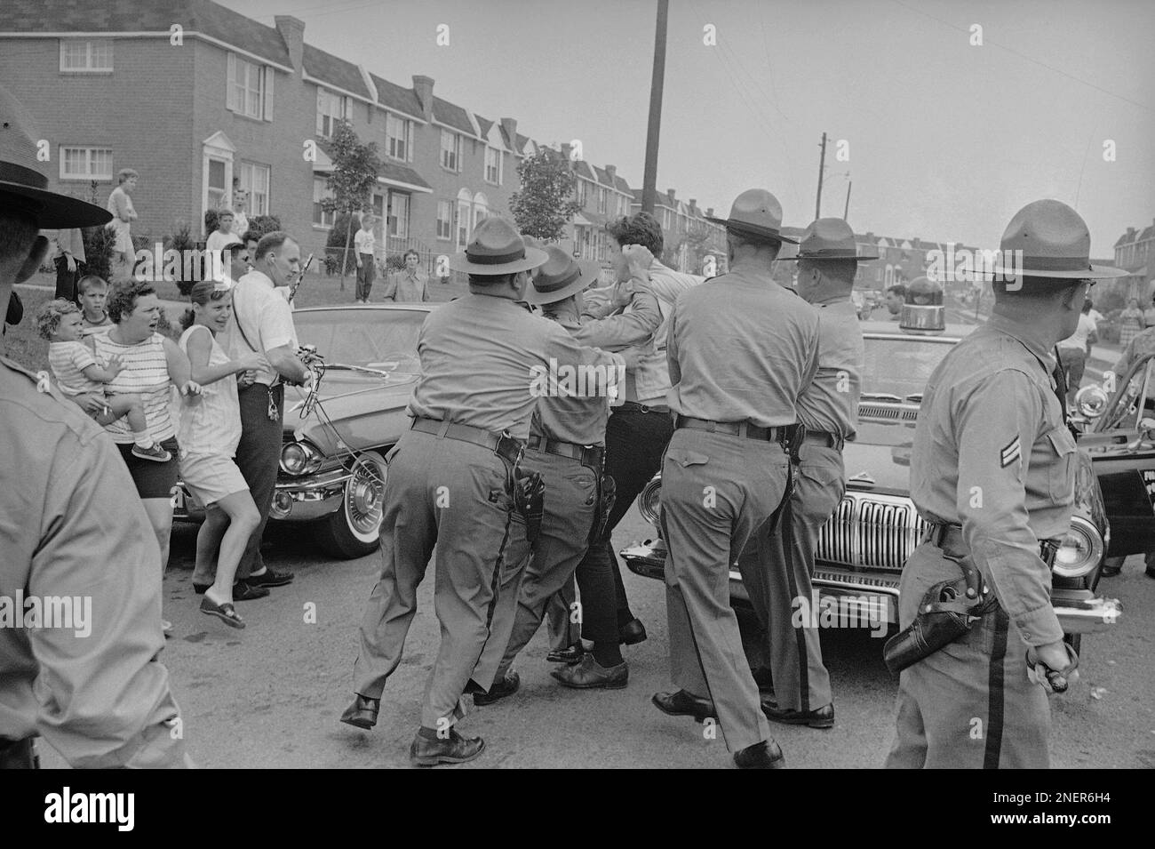 While State police haul off a demonstrator protesting an African American family moving into an
