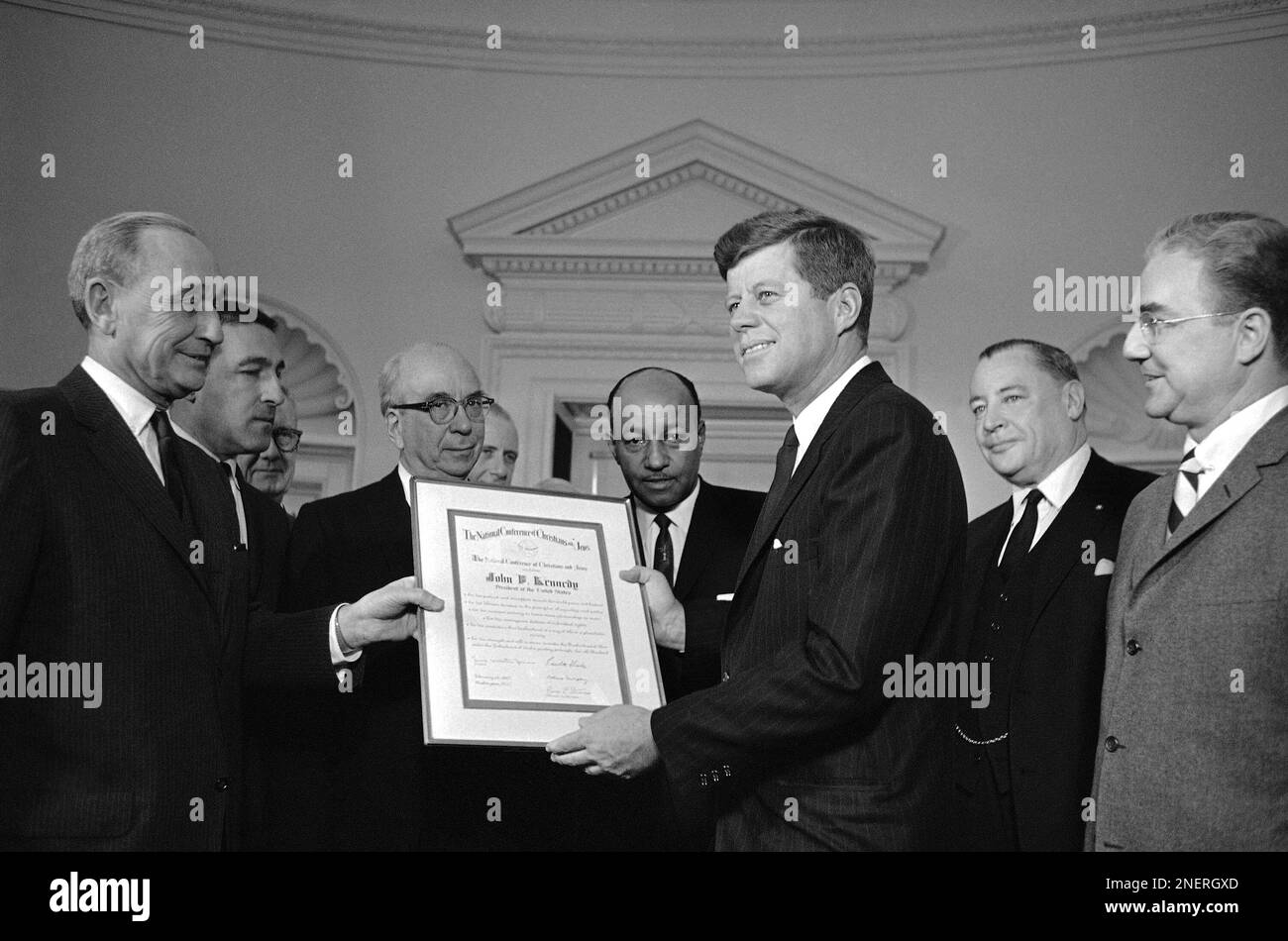 President John Kennedy displays the Brotherhood Award of 1962 presented to him at the White