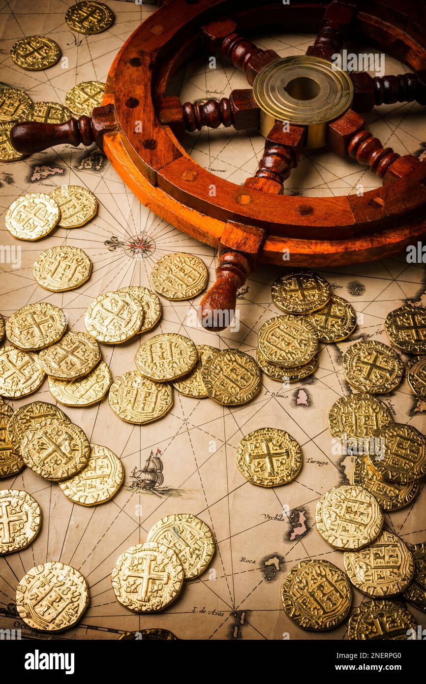Ships Wheel And Gold Coins On Old Map Stock Photo