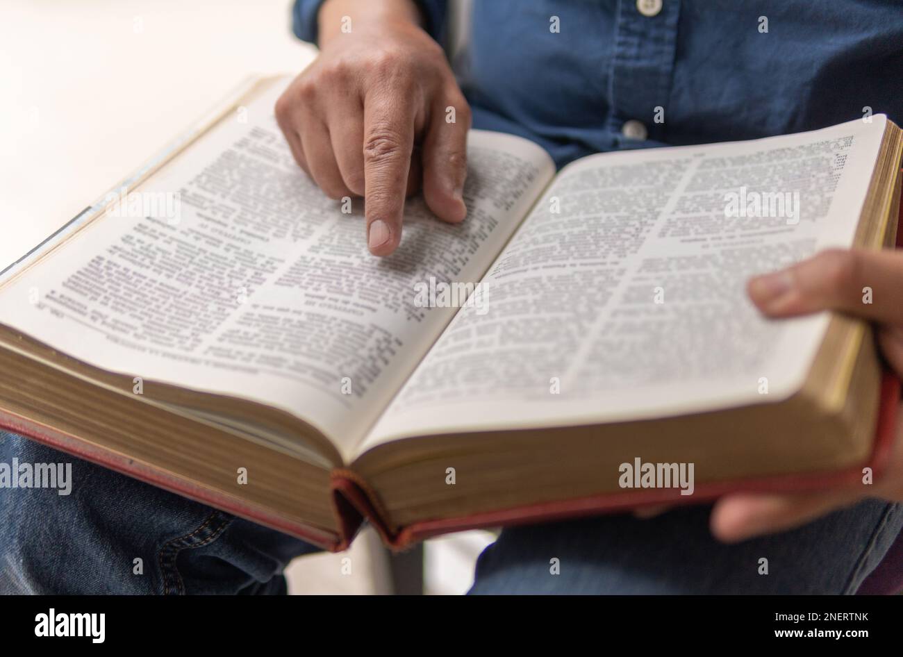 unrecognizable person sitting studying the bible with selective focus