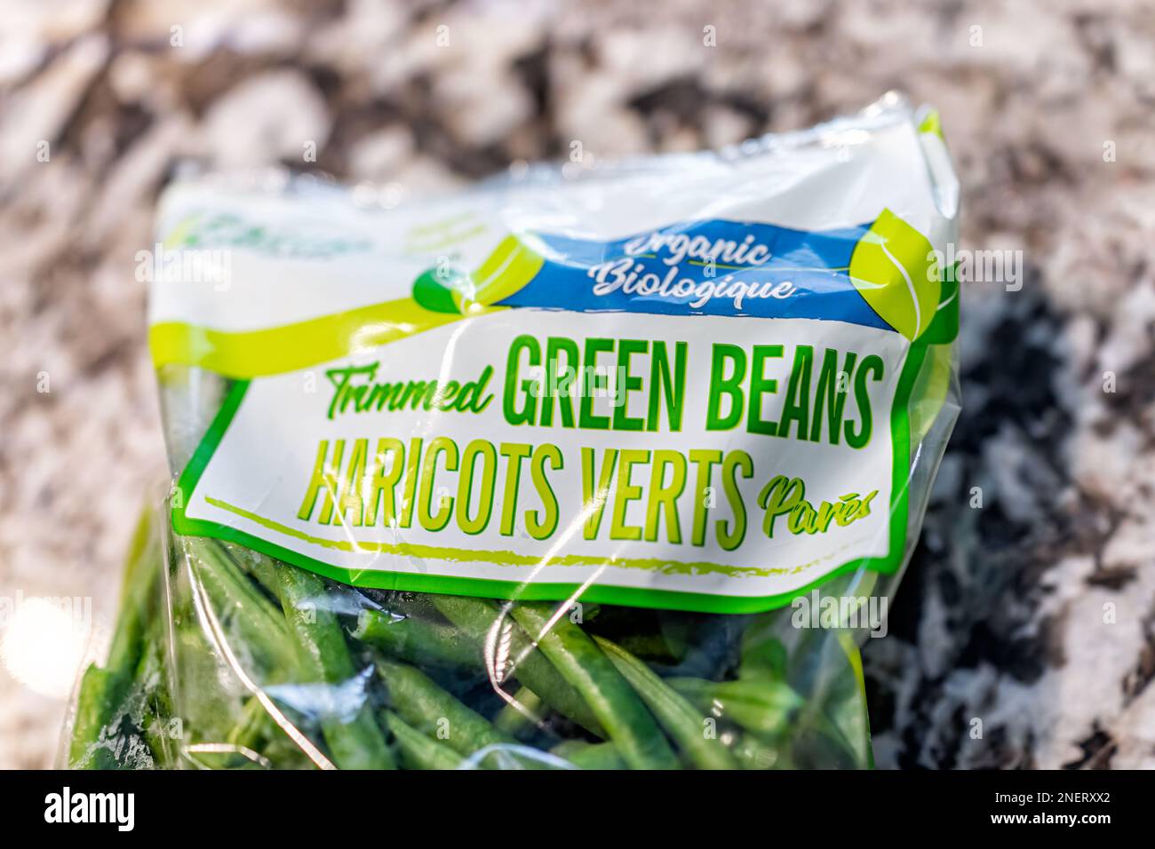 Avon, USA - June 17, 2022: Closeup of plastic bag of trimmed green beans haricots verts with organic biologique sign in french translation as bulk pro Stock Photo