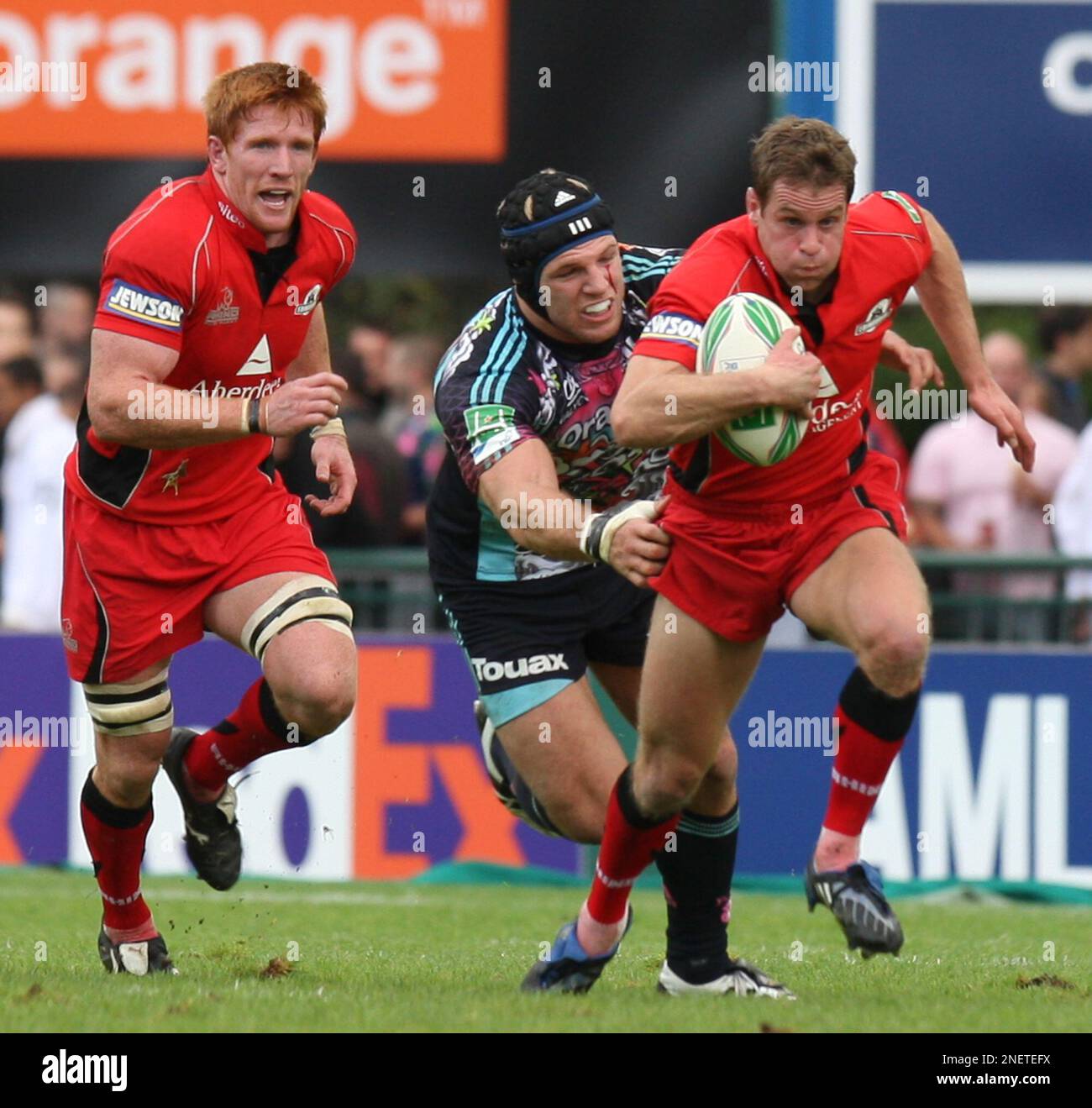 Stade Francais player James Haskell, center, tries to stop an unidentified Edinburgh player during their Heineken European Cup rugby union match in Paris, France, Saturday Oct