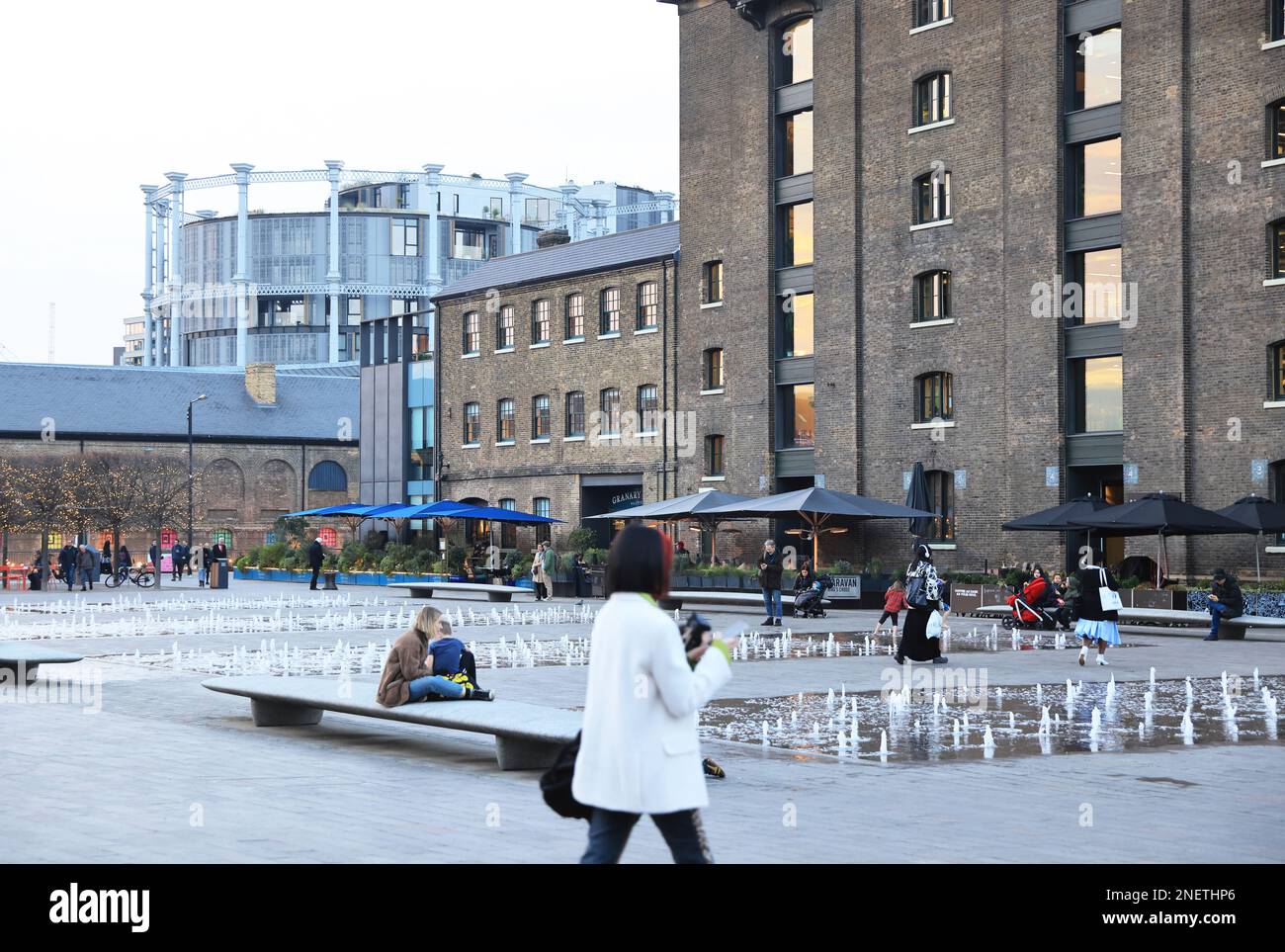 Winter sunshine on St Martins Central School of Art and the Granary Square fountains, at Kings Cross, north London, UK Stock Photo