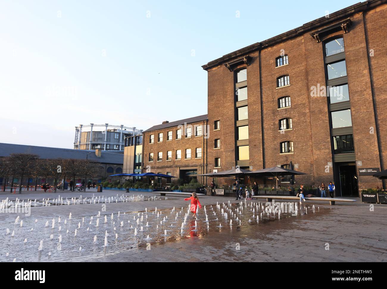 Winter sunshine on St Martins Central School of Art and the Granary Square fountains, at Kings Cross, north London, UK Stock Photo