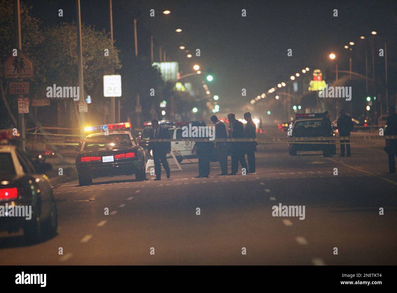 Los Angeles police officers examine the scene where a 24-year-old ...