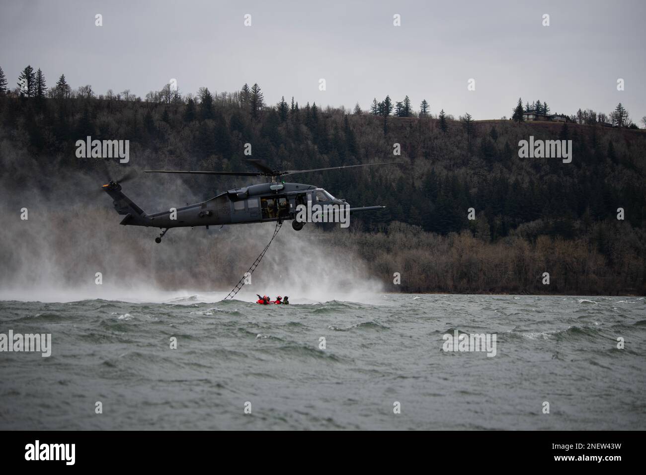 304th Rescue Squadron pararescuemen prepare for air evacuation as a 305th RQS HH-60G Pave Hawk helicopter positions itself during a combat search and rescue training scenario in the Columbia River Gorge, near Corbett, Oregon, Jan. 12, 2023. The two 943d Rescue Group, Davis-Monthan Air Force Base, Arizona, units carried out various rescue scenarios, ensuring Airmen are able to perform search and rescue operations in a variety of conditions and environments. (U.S. Air National Guard photo by Master Sgt. Steph Sawyer) Stock Photo