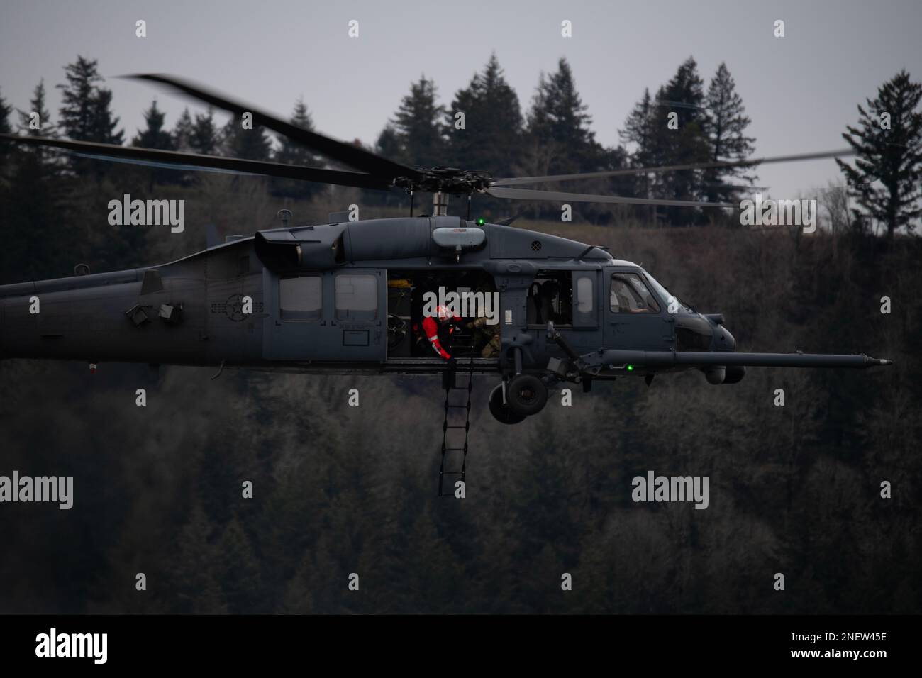 A 305th Rescue Squadron HH HH-60G Pave Hawk helicopter hovers over the Columbia River Gorge near Corbett, Oregon, during a combat search and rescue training exercise with the 304th RQS, Jan. 12, 2023. The two 943d Rescue Group, Davis-Monthan Air Force Base, Arizona, units carried out various rescue scenarios, ensuring Airmen are able to perform search and rescue operations in a variety of conditions and environments. (U.S. Air National Guard photo by Master Sgt. Steph Sawyer) Stock Photo