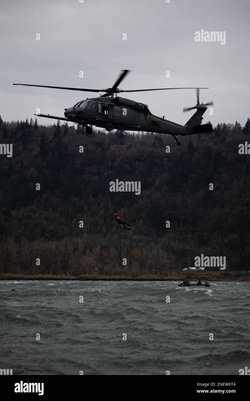 A 304th Rescue Squadron pararescueman is lifted out of the Columbia River Gorge near Corbett, Oregon, by a 305th RQS HH-60G Pave Hawk helicopter during a combat search and rescue training exercise, Jan. 12, 2023. The two 943d Rescue Group, Davis-Monthan Air Force Base, Arizona, units carried out various rescue scenarios, ensuring Airmen are able to perform search and rescue operations in a variety of conditions and environments. (U.S. Air National Guard photo by Master Sgt. Steph Sawyer) Stock Photo