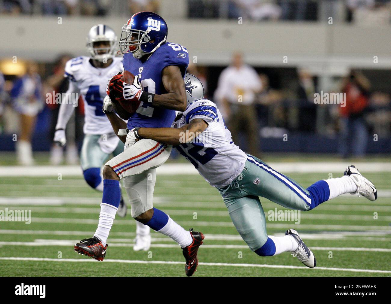 New York Giants wide receiver Mario Manningham (82) is tackled by Dallas Cowboys cornerback Orlando Scandrick (32) during an NFL football game,Sunday, Sept. 20, 2009, in Arlington, Texas. (AP Photo/LM Otero) Stock Photo