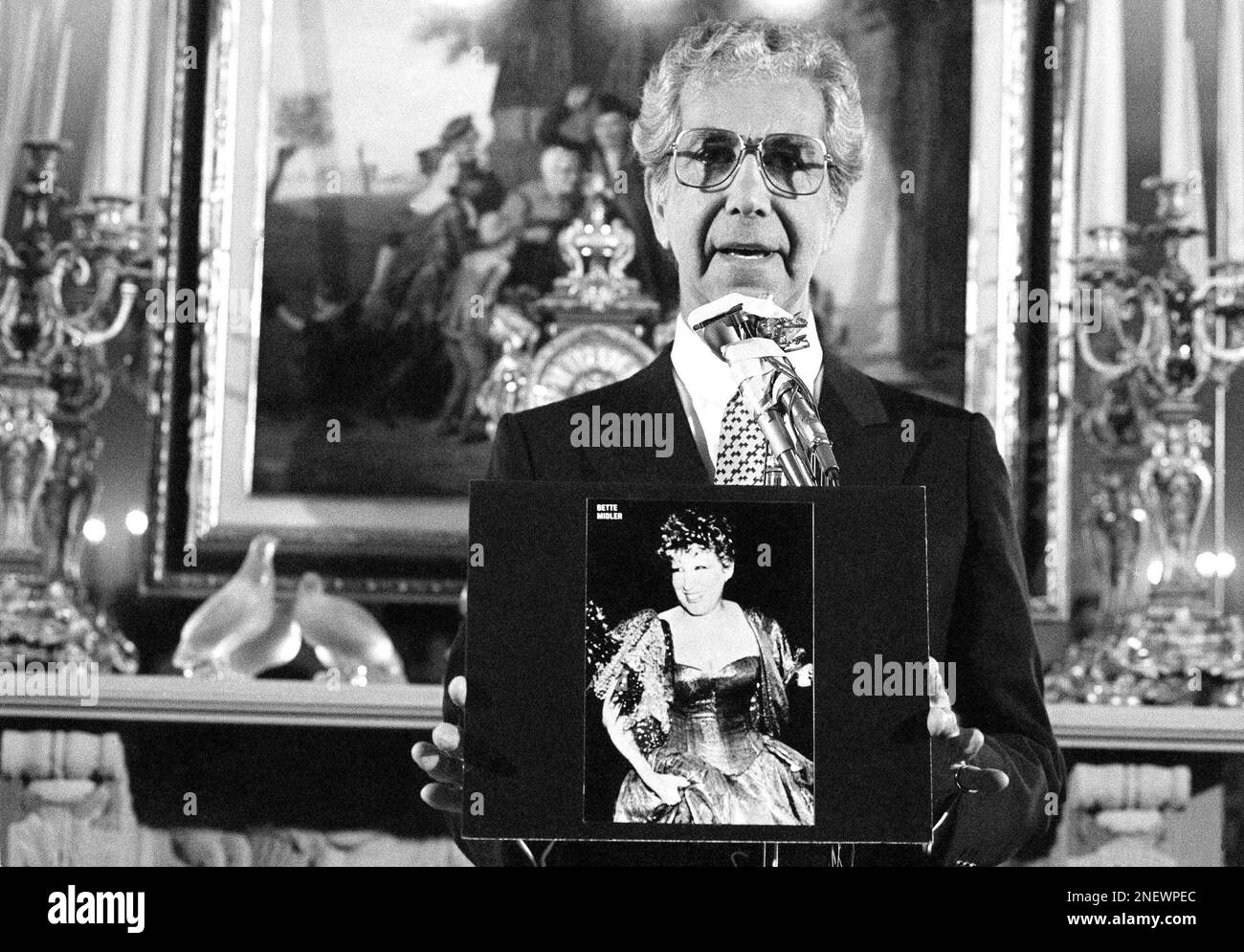 Fashion designer Mr. Blackwell holds photos of those included on his