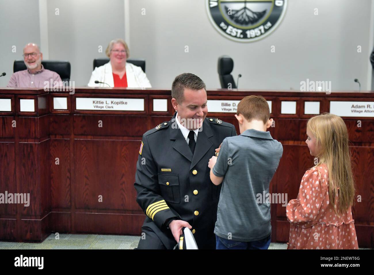 Streamwood, Illinois, USA. Newly promoted firefighter having his new badge pinned to his uniform by his children. Stock Photo