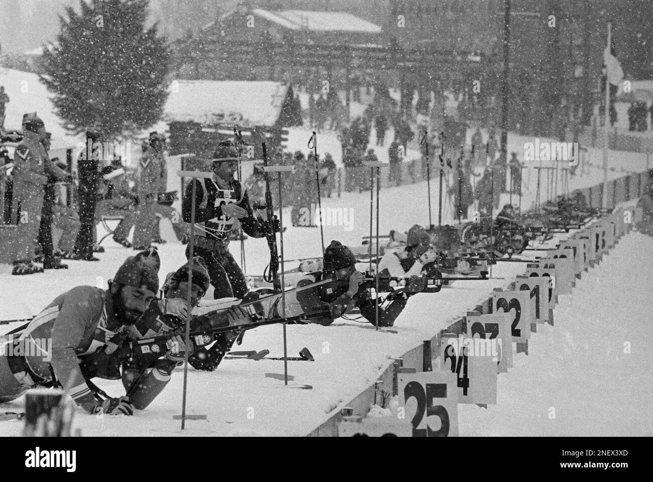 Under heavy snow competitors of the relay biathlon event are seen at