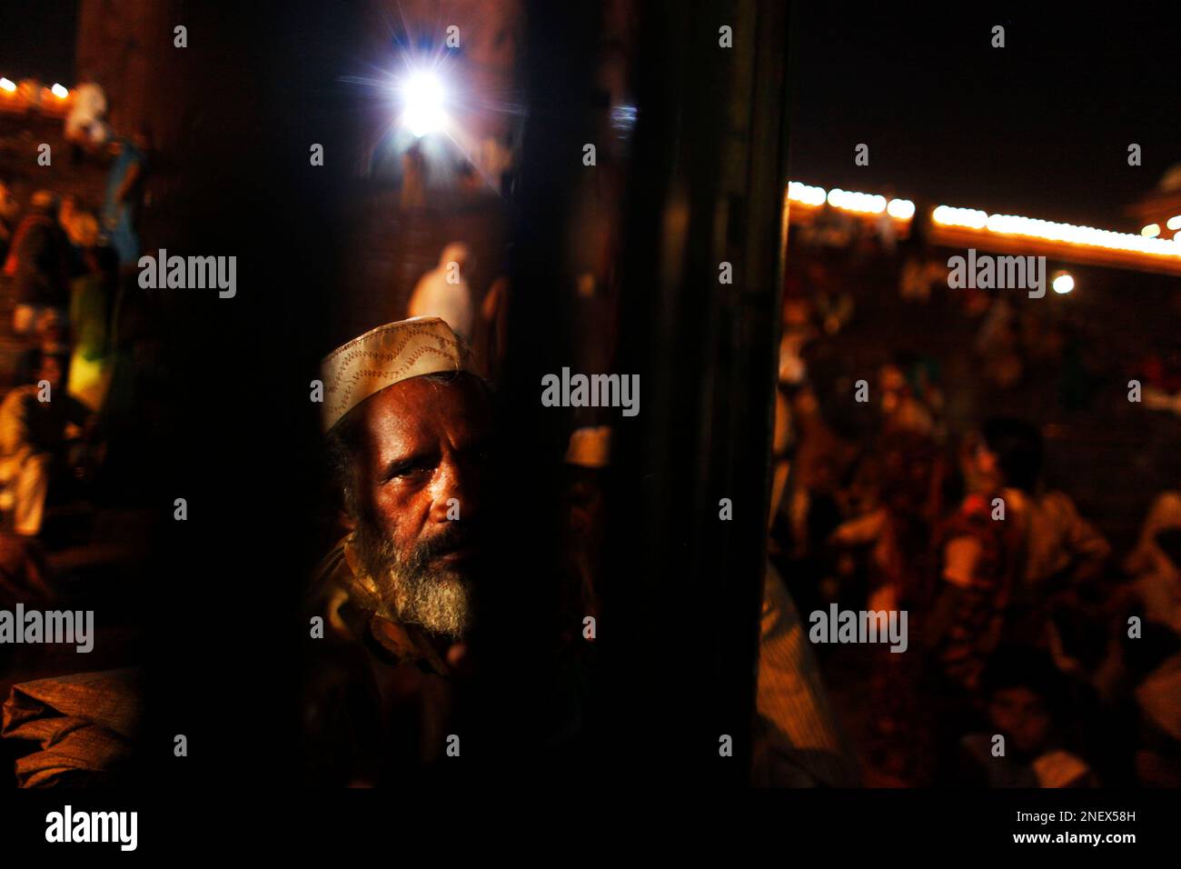 An Indian Muslim beggar waits so that he can beg for alms, from worshippers  as they leave their evening prayers during the holy fasting month of  Ramadan at the Jama Masjid Mosque