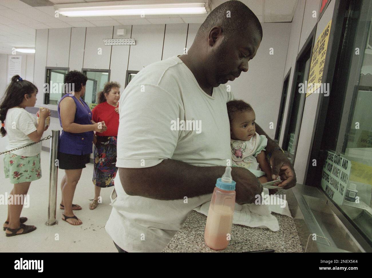 Jonathan Cobb and his seven month old daughter Joannie cash a check at