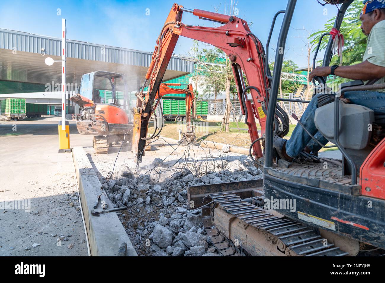 Jackhammer on an excavator are demolishing floor in factory Stock Photo