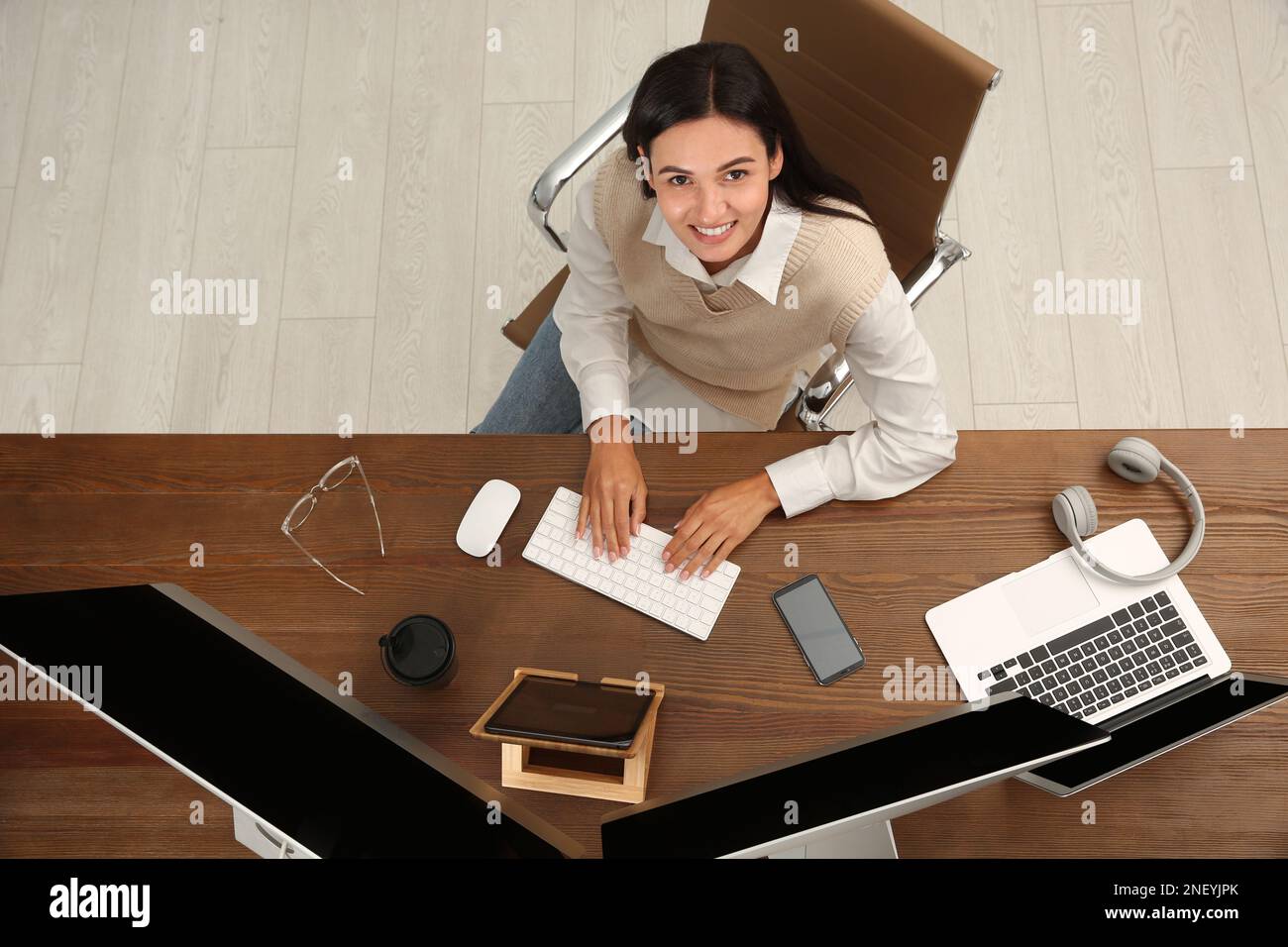 Happy programmer working at desk in office, top view Stock Photo