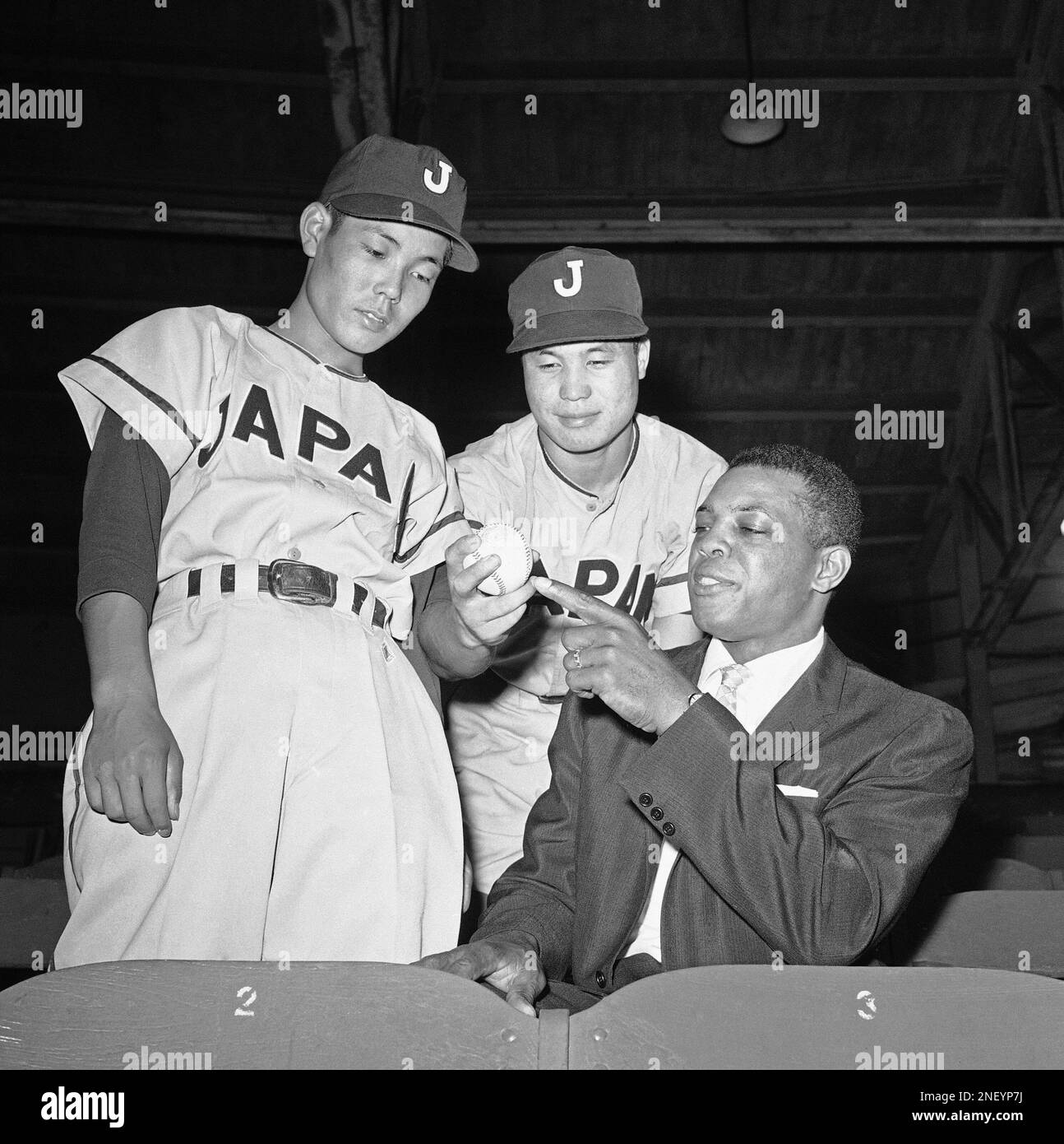 Willie Mays, right, San Francisco Giants' outfielder, gets some pointers on  the Japanese screw-ball from Tetsuo Kaneko, center, star pitcher for the  Japan High School All-Star team during their game with the