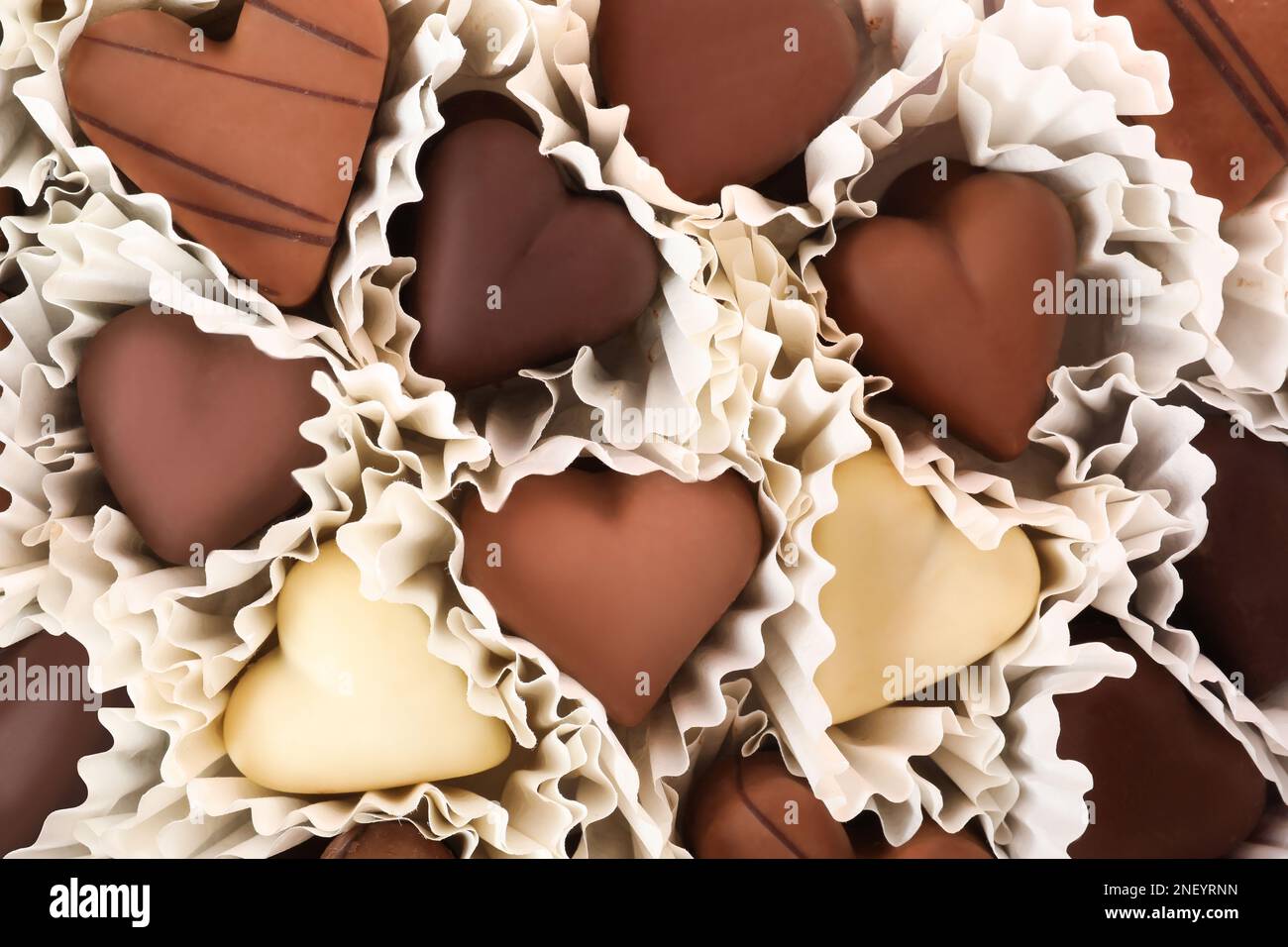 Delicious heart shaped chocolate candies as background, closeup Stock