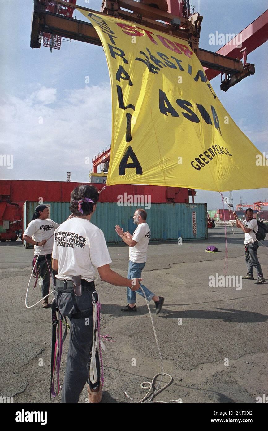 Greenpeace activists unfurl a giant banner near two 40-foot container vans  (back ground) allegedly containing hazardous computer scrap from Australia  and unloaded from a Russian merchant ship, MV Gamzat Tsadasa, early,  Wednesday,