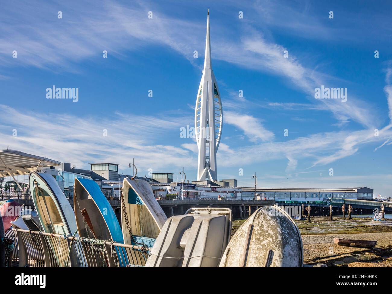 The Spinnaker Tower in Portsmouth Harbour seen from The Common's shorline in Portsea with Portsmouth Harbour train station in the foreground Stock Photo