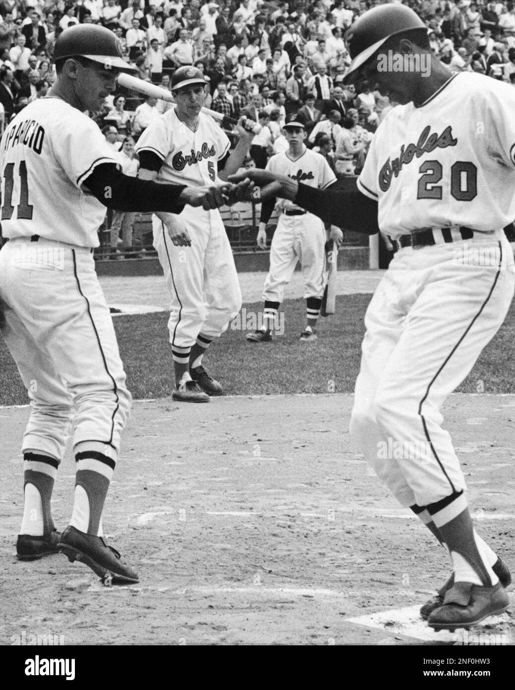 Baltimore's Frank Robinson (20) is greeted at home plate by